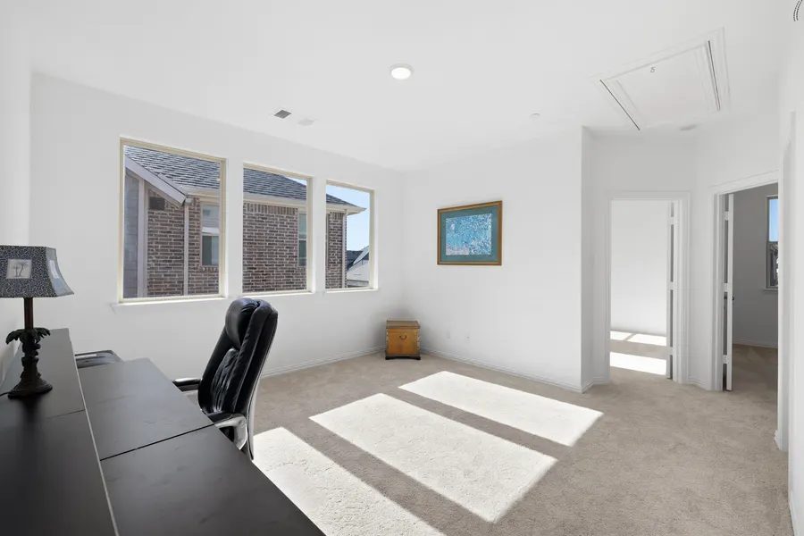 Secondary bedroom with two windows overlooking neighboring rooftops at 4335 Fall Blossom Dr