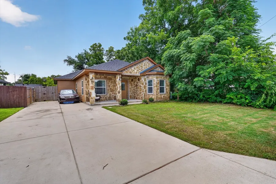 Front exterior of 4552 Corregidor St with the covered stone porch and driveway