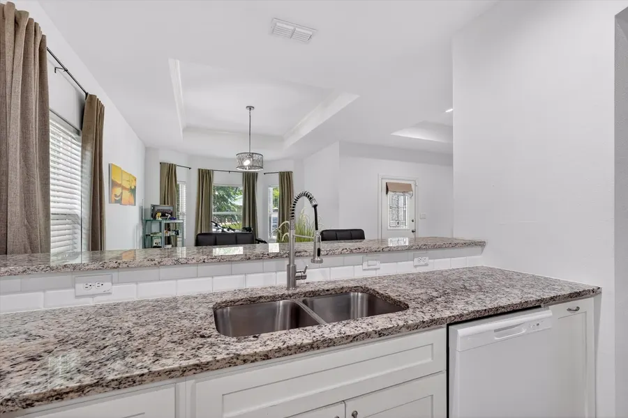 Kitchen sink and granite counters with a view to the dining area at 4552 Corregidor St