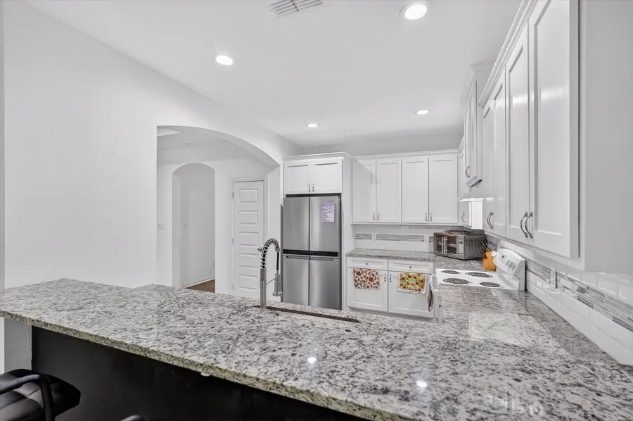 Kitchen with white cabinets and a stainless refrigerator at 4552 Corregidor St