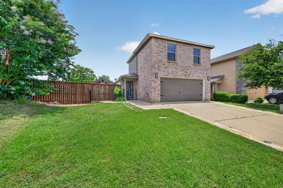 Angled view of the front yard, privacy fence, and driveway at 716 River Hill Ln