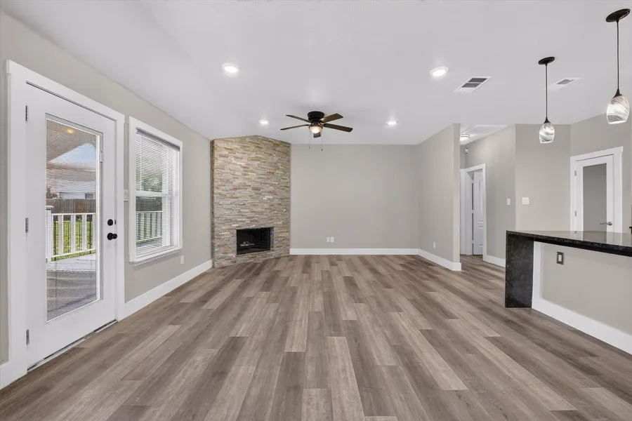 Living room fireplace wall with the back door and kitchen counter at 716 River Hill Ln