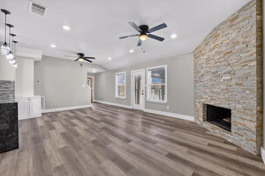 Wide living room view with two ceiling fans and the stone fireplace at 716 River Hill Ln