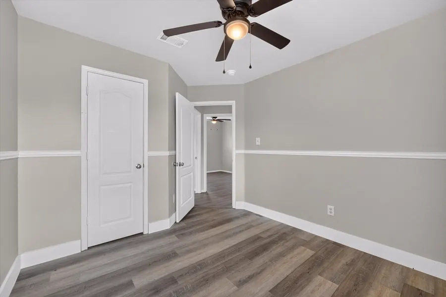 Bedroom with a ceiling fan and two paneled doors at 716 River Hill Ln