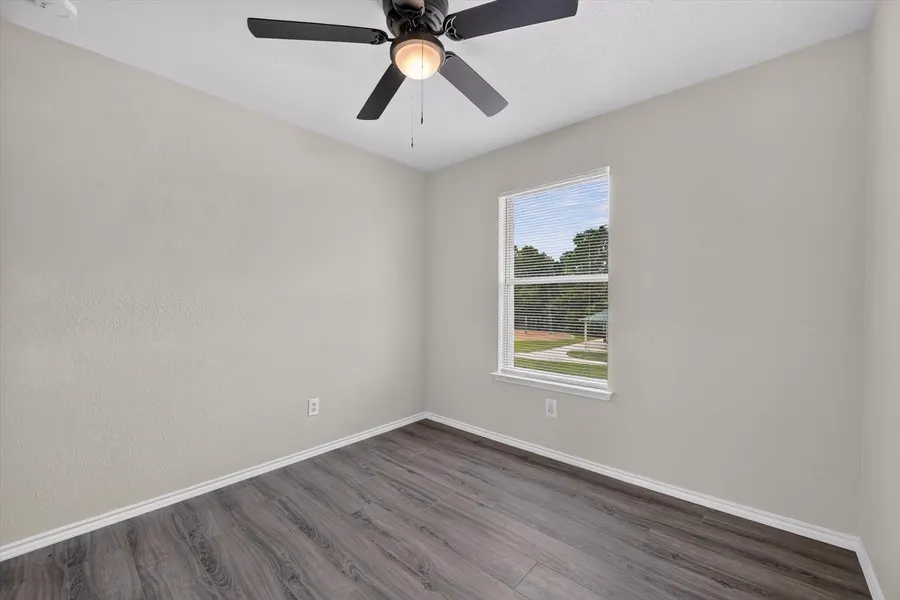 Bedroom with a ceiling fan and a window looking over the backyard at 716 River Hill Ln