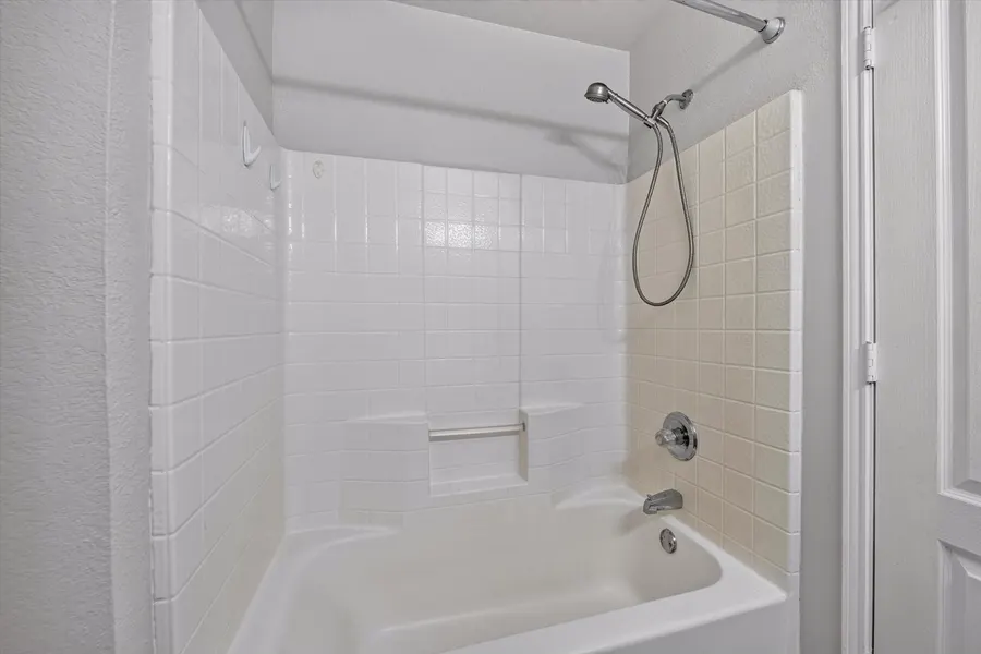 Bathroom with a tiled tub and shower surround at 716 River Hill Ln