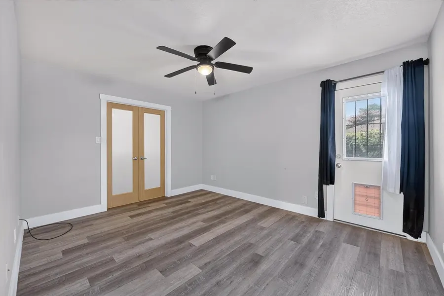 Bedroom with frosted French doors and a door out to the backyard at 716 River Hill Ln