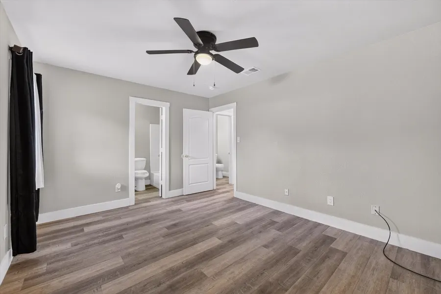 Primary bedroom with a ceiling fan and the door to its en suite bath at 716 River Hill Ln