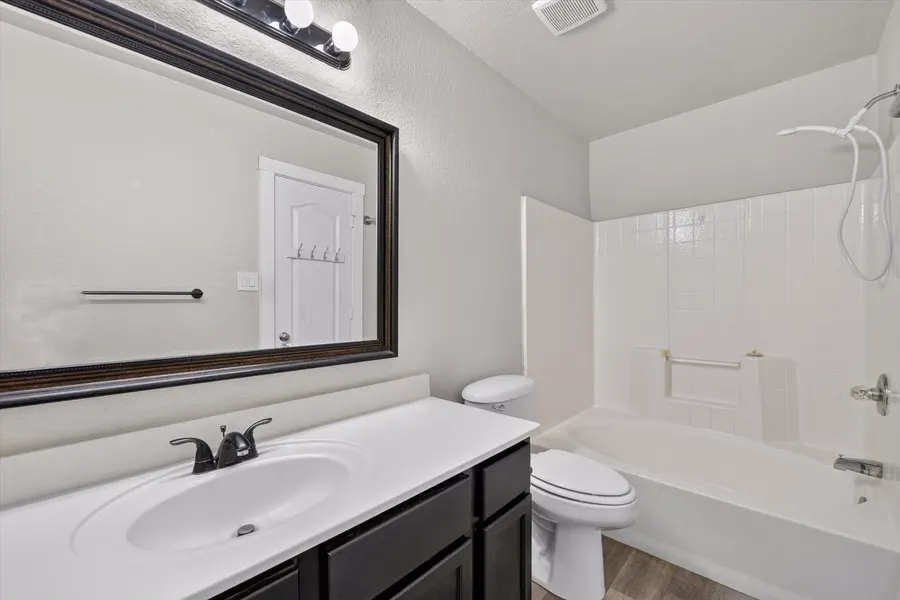 Full bath with a framed mirror, dark vanity, and tub shower at 716 River Hill Ln