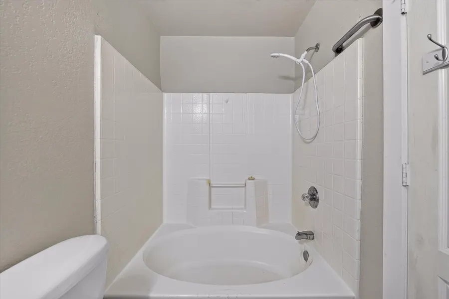 Tub and shower with a white tile surround at 716 River Hill Ln