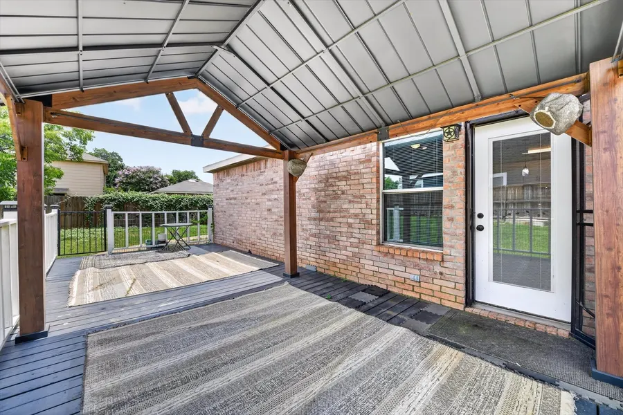 Covered rear porch with cedar beams and a metal roof off the living room at 716 River Hill Ln