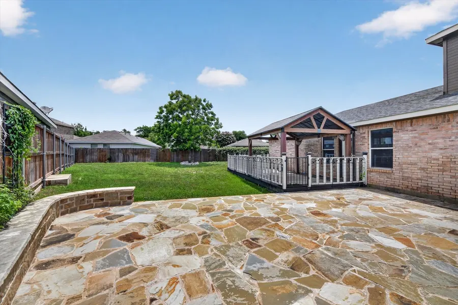 Flagstone patio looking across the lawn to the covered rear porch at 716 River Hill Ln