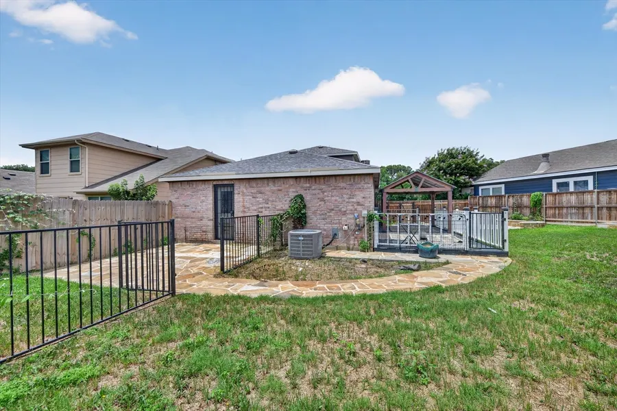 Rear elevation with the wrought iron fence and covered porch at 716 River Hill Ln