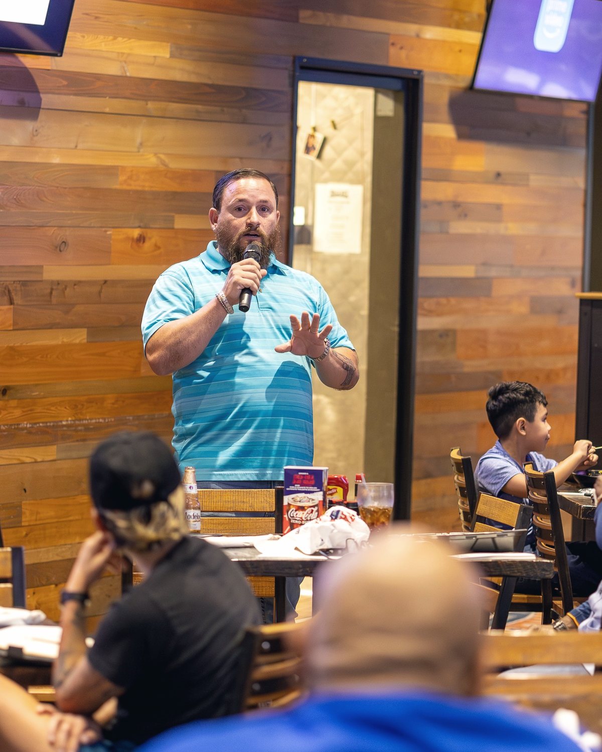 Mike Ritrovato speaking into a microphone at a VA home loan seminar in Dallas-Fort Worth